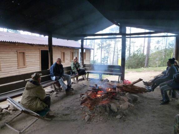 Esquentando-se na fogueira no fim de tarde gelado no refúgio do Pico Duarte, na República Dominicana